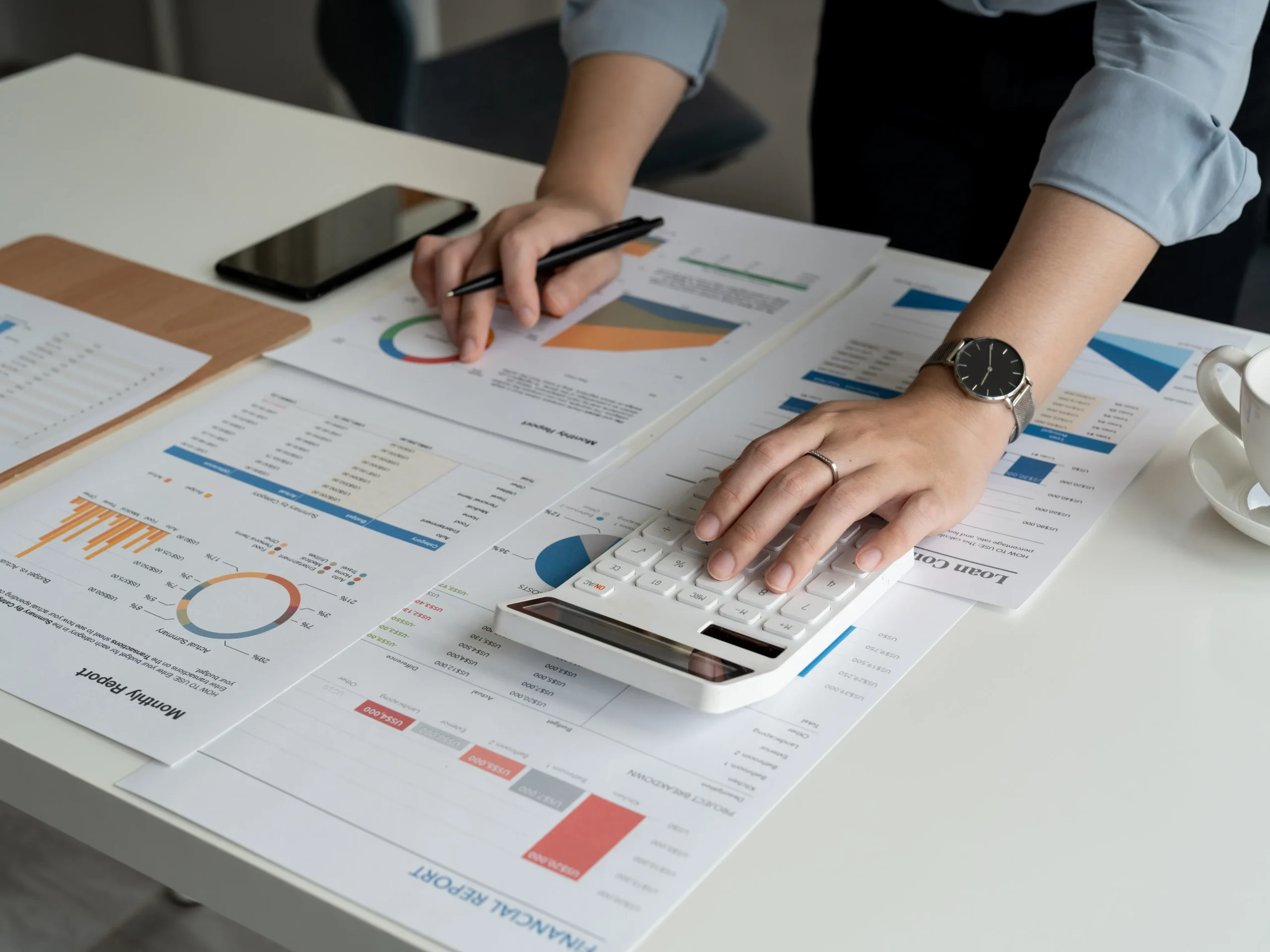person using calculator to plan their advertising budget breakdown