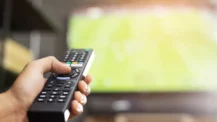 TV Advertising ROI Blog Cover Image of person holding remote pointed at television