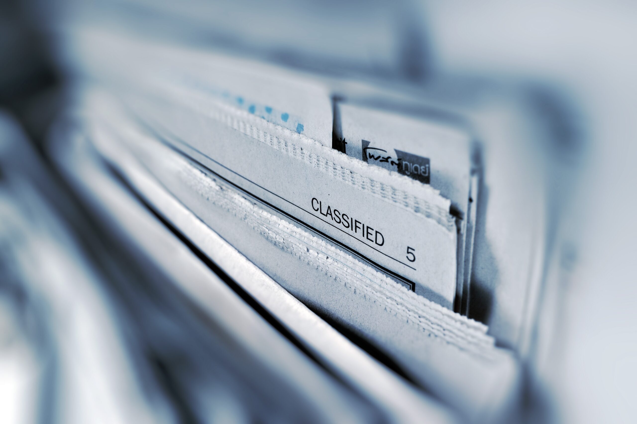 stack of newspapers with "classified" heading in the center