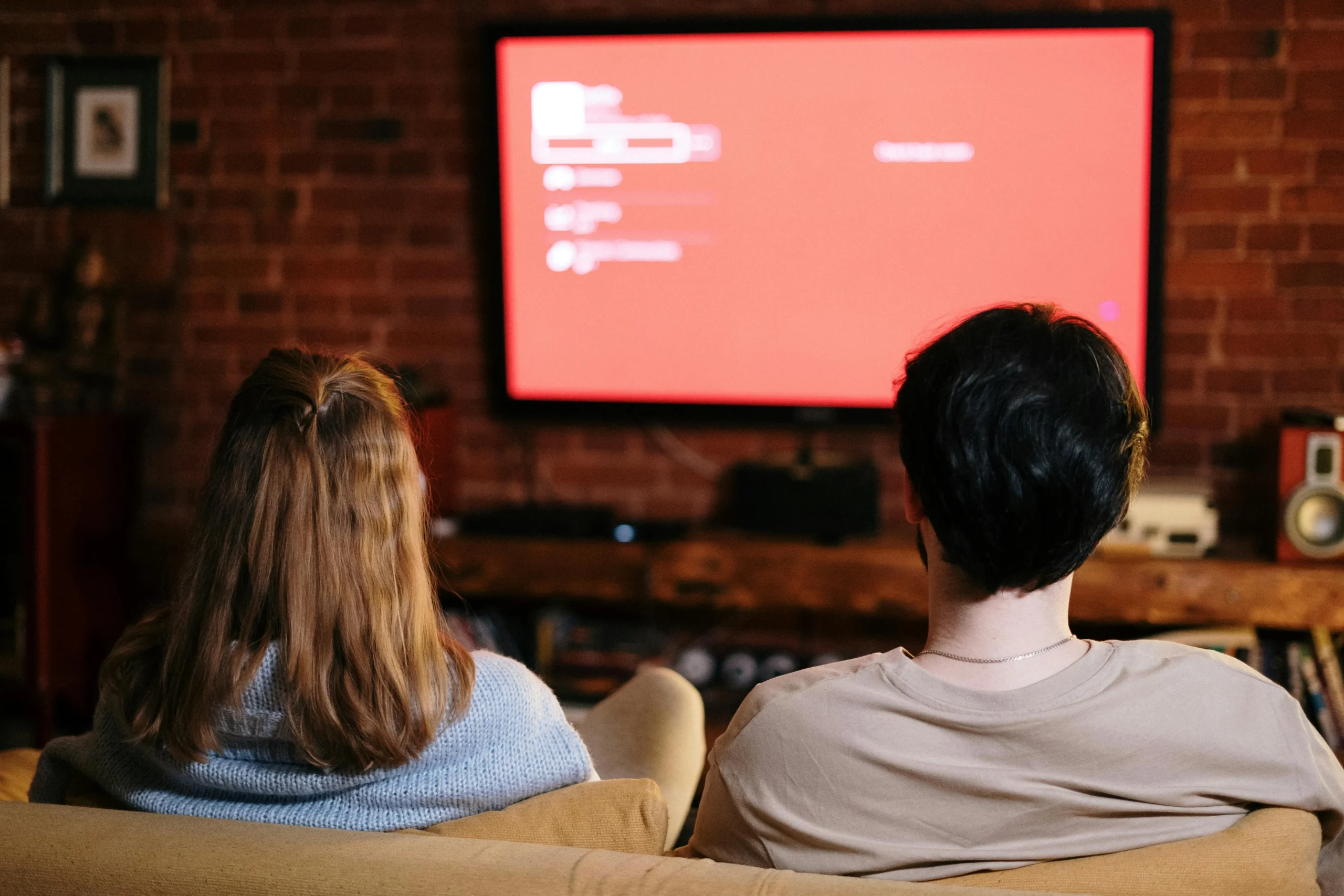 couple sitting on couch watching tv
