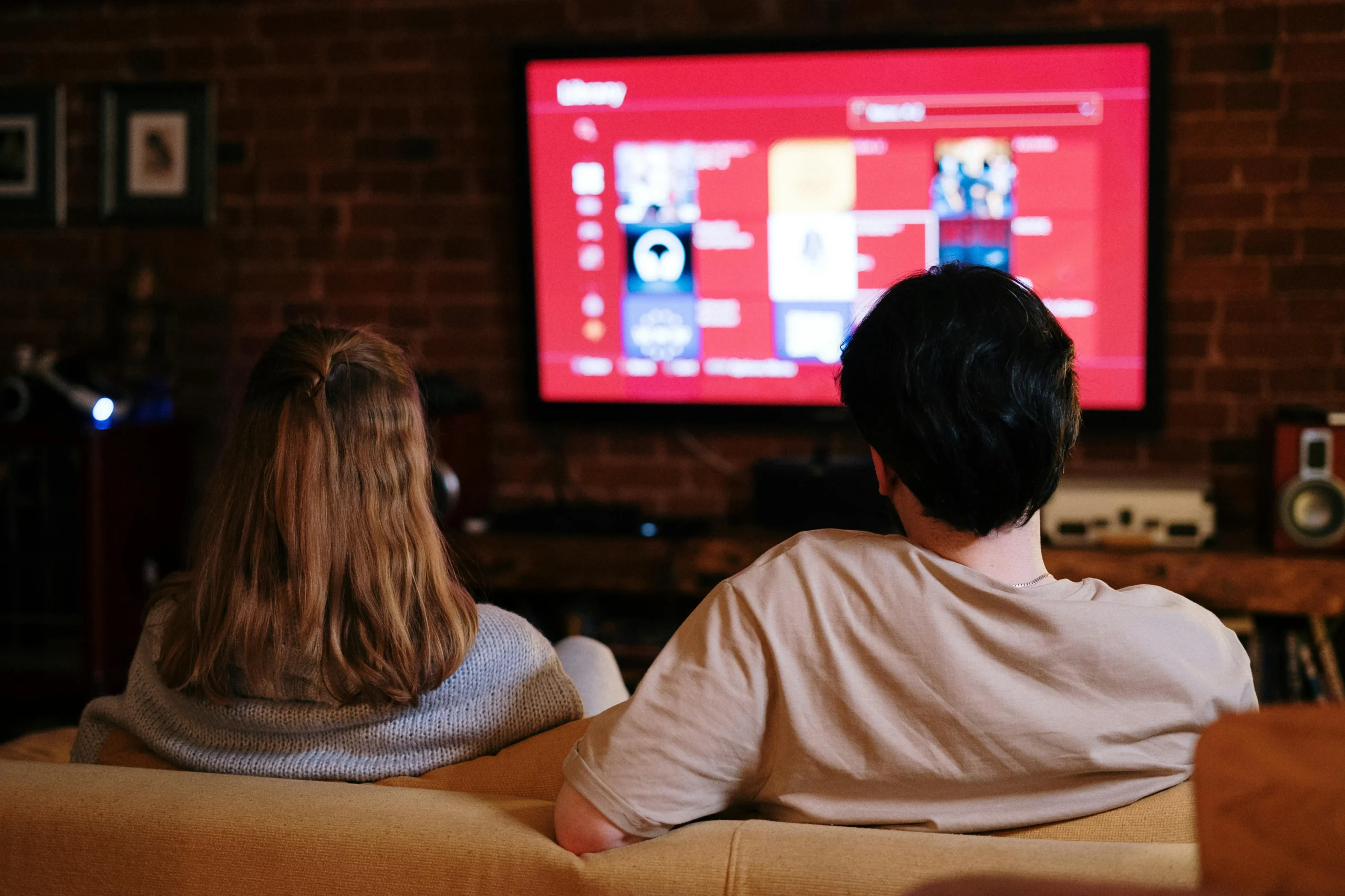 Couple sitting on couch looking at tv 