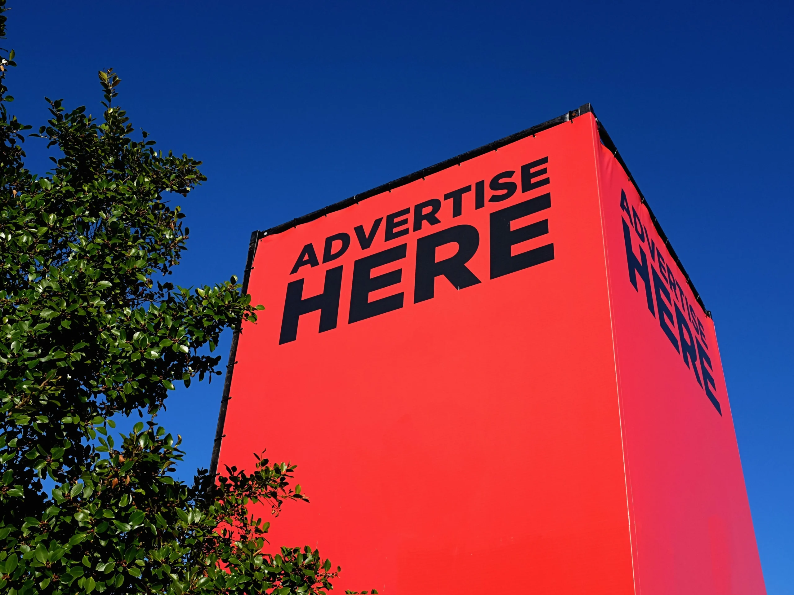 big red advertisement on side of the building for out-of-home advertising
