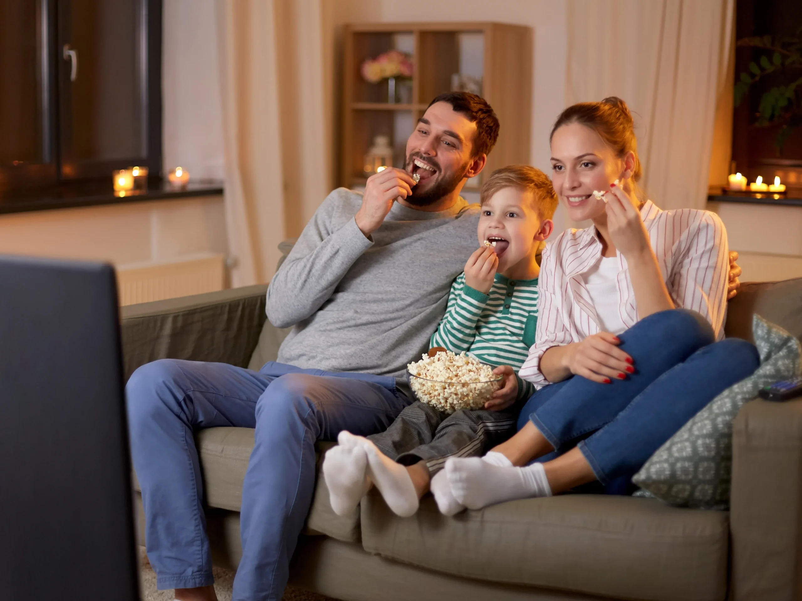 family enjoying a tv advertisement and eating popcorn